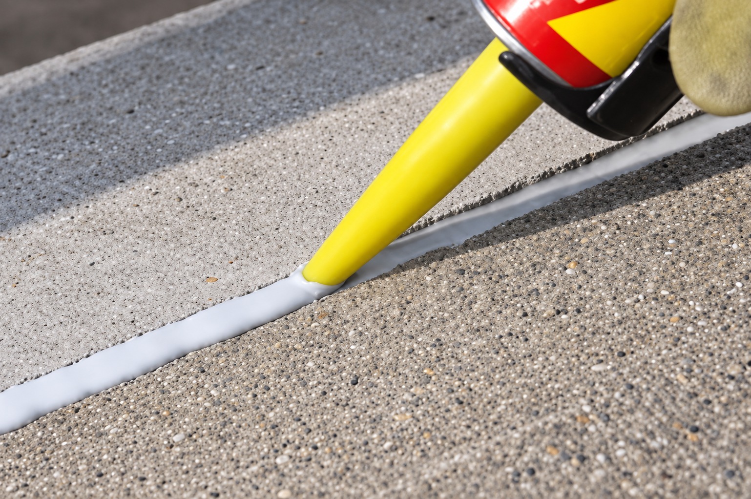 Application of flexible sealant to a pool deck expansion joint