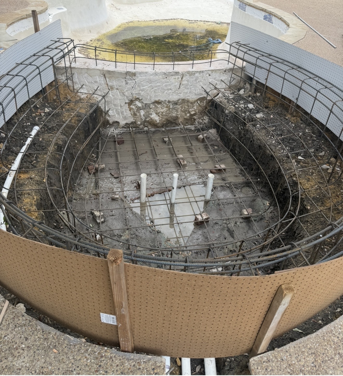 Before construction: round spa excavation with reinforcing steel, forms and PVC plumbing